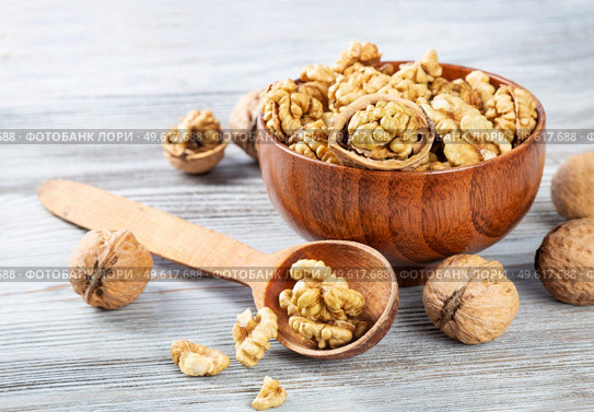 Purified walnuts in a brown wooden bowl on a wooden background. . Стоковое фото, агентство Ingram Publishing / Фотобанк Лори