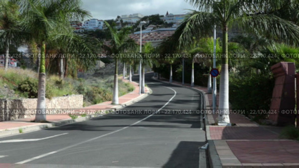 Пустая асфальтовая дорога к жилому району в городе Коста Адехе (Costa Adeje). Тенерифе, Канарские острова. Испания (2016 год). Стоковое видео, видеограф Кекяляйнен Андрей / Фотобанк Лори