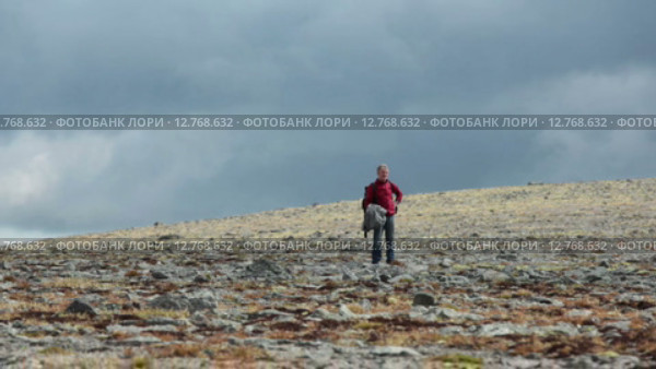 Путешественник стоит на горном плато вдалеке, грозовые тучи на небе. Хибины. Стоковое видео, видеограф Кекяляйнен Андрей / Фотобанк Лори
