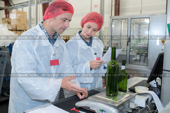 Quality control operative weighing empty bottle. Стоковое фото, агентство Ingram Publishing / Фотобанк Лори