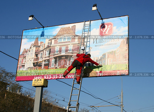 Работа на высоте. Расклейщик рекламы (2010 год). Редакционное фото, фотограф Щеголева Ольга / Фотобанк Лори