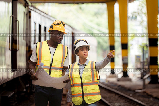 Railway technicians and engineers, Inspect the trains in train repair station before being used to drag train cars to receive or transport goods and people. Стоковое фото, агентство Ingram Publishing / Фотобанк Лори