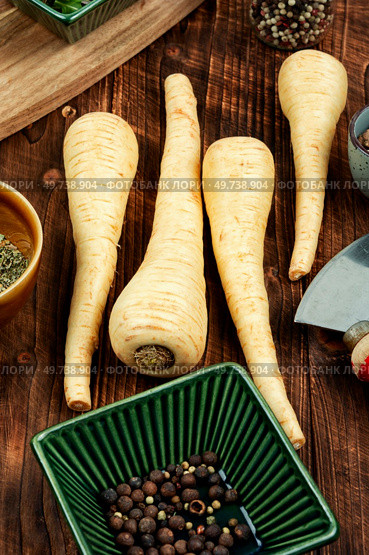 Raw and uncooked parsnips roots on the kitchen table. Raw parsnip roots on wooden table. Стоковое фото, агентство Ingram Publishing / Фотобанк Лори