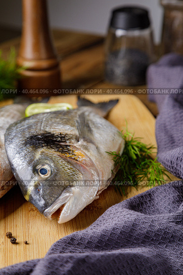 Raw peeled dorado fish with cooking ingredients. Fresh fish on a wooden background. Стоковое фото, фотограф Юрий Поздников / Фотобанк Лори