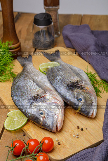 Raw peeled dorado fish with cooking ingredients. Fresh fish on a wooden background. Стоковое фото, фотограф Юрий Поздников / Фотобанк Лори