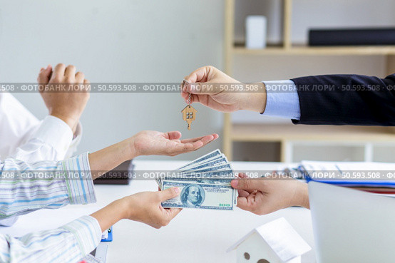 Real estate agent giving keys to couple of customers. Trading house for rent and insurance. Стоковое фото, агентство Ingram Publishing / Фотобанк Лори