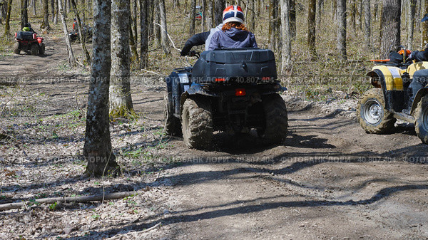 Rear view of a group of ATV riders driving along a forest dirt road. Extreme type of outdoor activities. Tourist trips on an quad bike. Стоковое фото, фотограф Воловодов Владимир / Фотобанк Лори