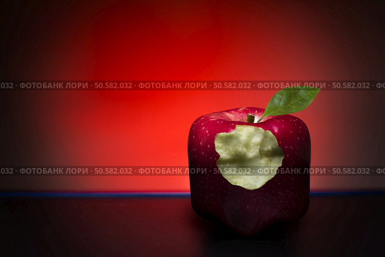 Red, bitten, cube apple on a red background and black floor. Стоковое фото, агентство Ingram Publishing / Фотобанк Лори