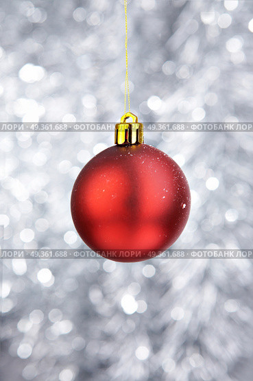 Red Christmas-tree decoration on a silvery background. Attribute of Christmas. Стоковое фото, агентство Ingram Publishing / Фотобанк Лори