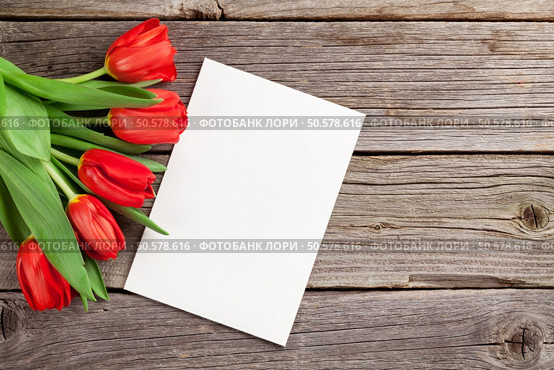 Red tulips and Valentine’s day greeting card on wooden table. View with copy space. Стоковое фото, агентство Ingram Publishing / Фотобанк Лори