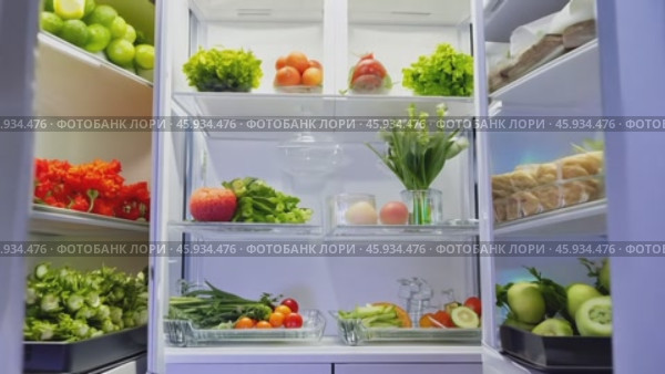 Refrigerator door opening to reveal an abundance of fresh food options. Стоковое видео, видеограф Данил Руденко / Фотобанк Лори