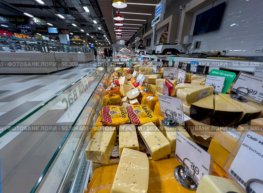 Refrigerator with cheese products from the supermarket "Spar" close-up. Russia. Moscow. 22.06.25. Редакционное фото, фотограф Ярославский Максим / Фотобанк Лори