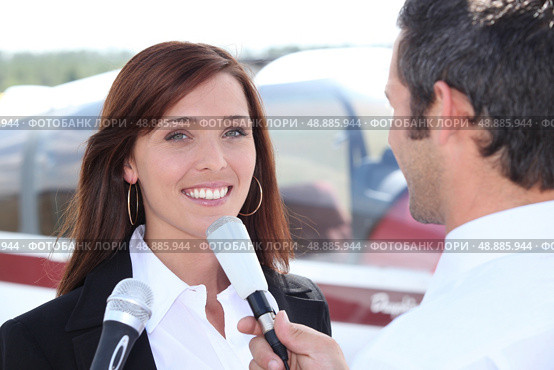 Reporter interviewing woman in airport. Стоковое фото, агентство Ingram Publishing / Фотобанк Лори