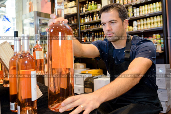 restocking bottles in liquor store. Стоковое фото, агентство Ingram Publishing / Фотобанк Лори