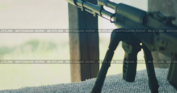 Rifle on support aimed toward range from behind wooden posts at training site. Стоковое видео, видеограф Ольга Сухарева / Фотобанк Лори