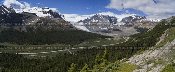 Road passing through mountainous landscape with glacier in the background, Columbia Icefields, Icefields Parkway, Jasper, Alberta, Canada. Стоковое фото, агентство Ingram Publishing / Фотобанк Лори