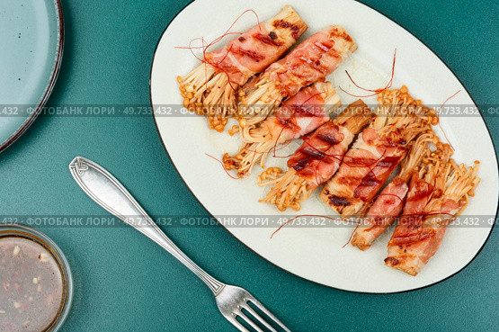 Roasted enoki mushrooms with bacon on the plate. Asian cuisine. Enoki mushrooms rolls, asian food. Стоковое фото, агентство Ingram Publishing / Фотобанк Лори