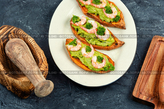 Roasted sweet potato, yam stuffed with prawns and avocado on a concrete kitchen table.. Baked, Stuffed Sweet Potatoes. Стоковое фото, агентство Ingram Publishing / Фотобанк Лори