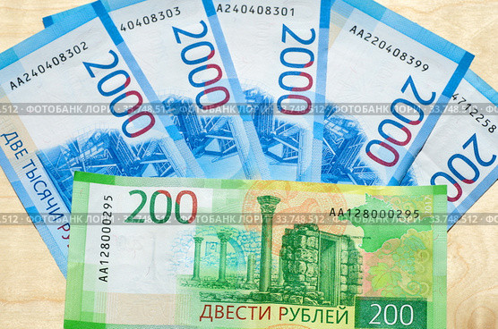 Российские деньги. Новые купюры номиналом 2000 и 200 рублей на деревянном фоне. Стоковое фото, фотограф Елена Коромыслова / Фотобанк Лори