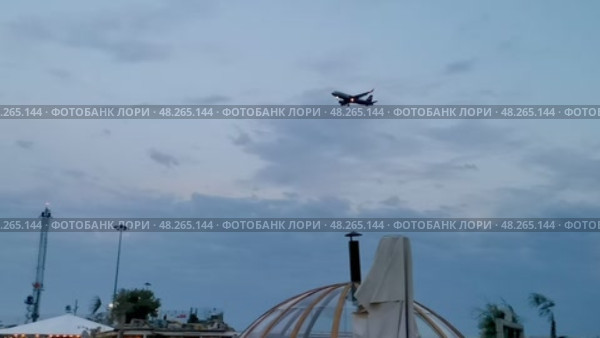 Россия, Краснодарский край, Сочи. Август 2024. Пляж SochiFornia. Ребенок на качелях на фоне моря и самолета на посадке. Редакционное видео, видеограф Сергей Татаринцев / Фотобанк Лори