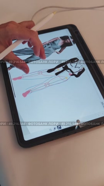 Рука девушки креатора держит пальцами pensil и рисует на планшете ipad pro изображение женщины модели в одежде в специальной программе для обучения художников для инстаграм и тик ток. Стоковое видео, видеограф Светлана Русских / Фотобанк Лори