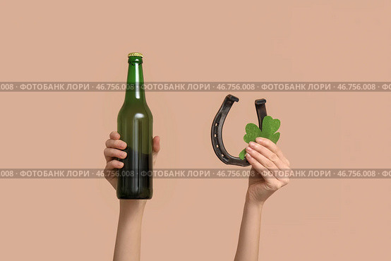 Руки с пивом, клевером и подковой на бежевом фоне. Празднование Дня святого Патрика. Стоковое фото, фотограф Pixel_shot / Фотобанк Лори