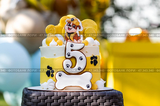 Russia, Moscow, 28 June 2024: Birthday cake at the children's birthday party "Puppy Patrol". Balloons in the background. The concept of a children's holiday in nature. Редакционное фото, фотограф Photojuli / Фотобанк Лори