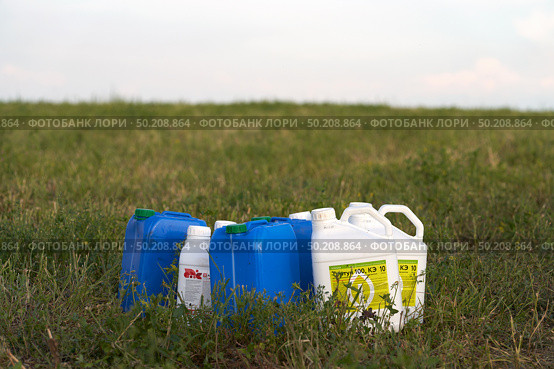 Russia, Naberezhnye Chelny, June 20, 2025: chemical weeding of a field. Use of herbicides in agriculture. Containers with a chemical preparation at the edge of a field after harvesting green fodder. Редакционное фото, фотограф Роман Дзюбало / Фотобанк Лори