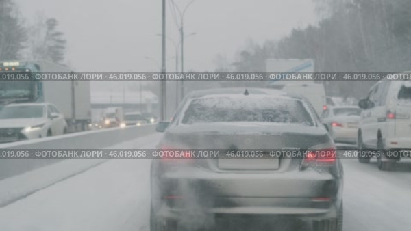 RUSSIA, NOVOSIBIRSK - DECEMBER 28, 2024: Traffic jam on the highway in snowfall in snowy winter. Редакционное видео, видеограф Георгий Мякишев / Фотобанк Лори