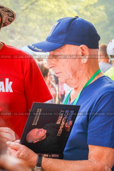 Russia, Samara, July 2016: Distribution of Alexander Gorodnitsky's autographs, at the Grushinsky festival on Mastryukovskie lakes on a summer day. Редакционное фото, фотограф Акиньшин Владимир / Фотобанк Лори