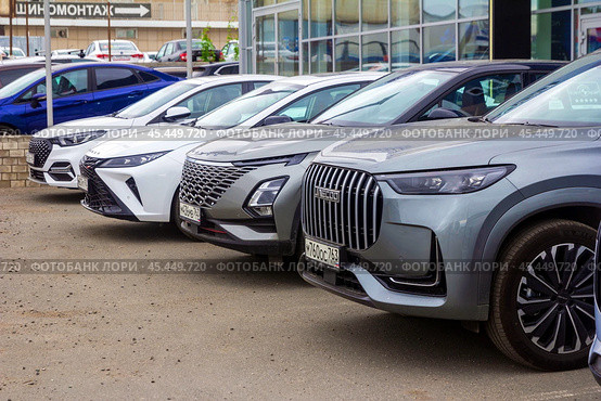 Russia. Samara, June 28, 2024: Chinese cars from the Amoda company are standing near the car dealership for sale. text in Russian: tire service car service. Редакционное фото, фотограф Акиньшин Владимир / Фотобанк Лори