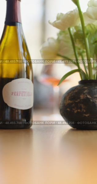Russia, St.Petersburg, 24 April 2025: bottle of champagne is on table, flowers, wine glass in the restaurant, local lighting, wine cabinet, decanters for sparkling wine. Редакционное видео, видеограф Vladimir Drozdin / Фотобанк Лори