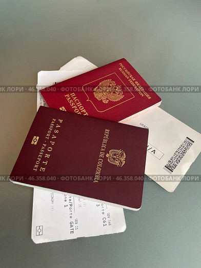 Russian and Colombian biometric passports with a couple of tickets. Стоковое фото, фотограф Виктор Ветошкин / Фотобанк Лори