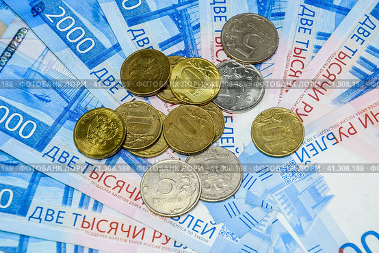Russian banknotes and coins. A handful of coins on new Russian banknotes in denominations of 2000 and 200 rubles. Стоковое фото, фотограф Леонид Еремейчук / Фотобанк Лори