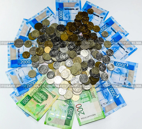Russian banknotes and coins. A handful of coins on new Russian banknotes in denominations of 2000 and 200 rubles. Стоковое фото, фотограф Леонид Еремейчук / Фотобанк Лори