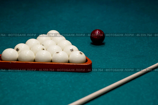 Russian billiards. Red and white balls are lying on a green billiard table. Spending time at home playing a hobby sports game. Стоковое фото, фотограф Photojuli / Фотобанк Лори