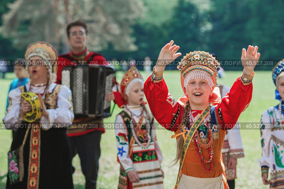 Russian folk traditions. Folk festivals. Children in beautiful Russian traditional outfits sing songs, dance and lead a round dance in Tsaritsyno Park. National Russian clothes. Sundresses and kokoshniks. (2023 год). Редакционное фото, фотограф Photojuli / Фотобанк Лори