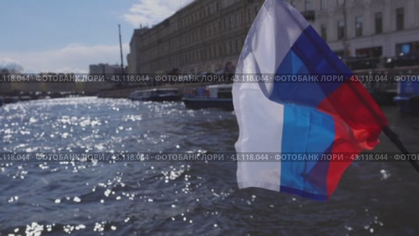 Russian tricolor on the stern of a boat in St. Petersburg against the background of the Moika River. (2024 год). Редакционное видео, видеограф Ярославский Максим / Фотобанк Лори