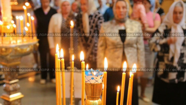 Русская православная церковь. Верующие. Горящие свечи на подсвечнике (2012 год). Редакционное видео, видеограф Mikhail Erguine / Фотобанк Лори