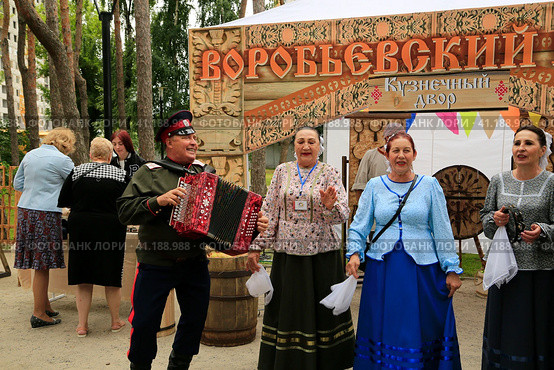 Русские народные артисты исполняют песни и частушки. Гармонист, гармонь. Фольклорный фестиваль в городе Воронеж. (2023 год). Редакционное фото, фотограф Надежда Глазкина / Фотобанк Лори