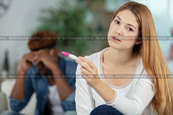 sad girl holding a pregnancy tester. Стоковое фото, агентство Ingram Publishing / Фотобанк Лори