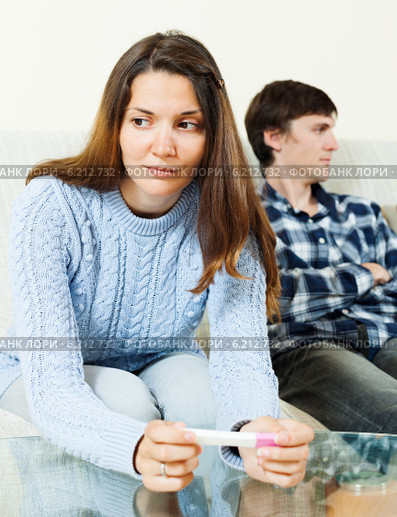 Sad woman with pregnancy test against boyfriend. Стоковое фото, фотограф Яков Филимонов / Фотобанк Лори