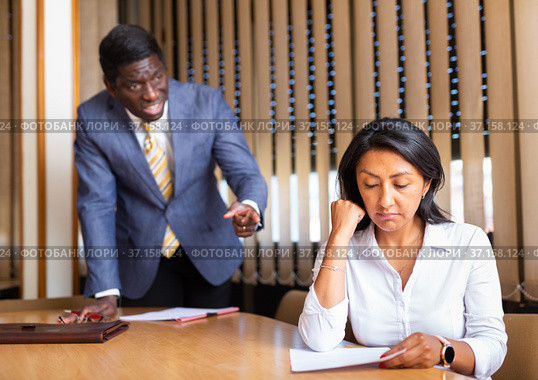 Saddened businesswoman sitting in office with dissatisfied male colleague. Стоковое фото, фотограф Яков Филимонов / Фотобанк Лори