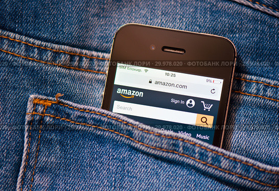 Сайт Amazon.com на экране телефона. Смартфон лежит в заднем кармане джинсовых штанов (2019 год). Редакционное фото, фотограф E. O. / Фотобанк Лори