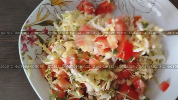 Салат из натуральных продуктов, капуста, огурцы, помидоры, зелень рука мешает ложкой салат. Salad made from natural products, cabbage, cucumbers, tomatoes, greens, hand stirs salad with a spoon. Стоковое видео, видеограф Наталья Пеньшина / Фотобанк Лори