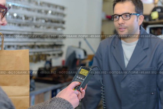 salesman accepting payment from customer through credit card. Стоковое фото, агентство Ingram Publishing / Фотобанк Лори