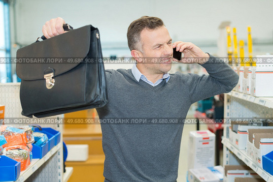 salesman raising his arms in frustration while on telephone. Стоковое фото, агентство Ingram Publishing / Фотобанк Лори
