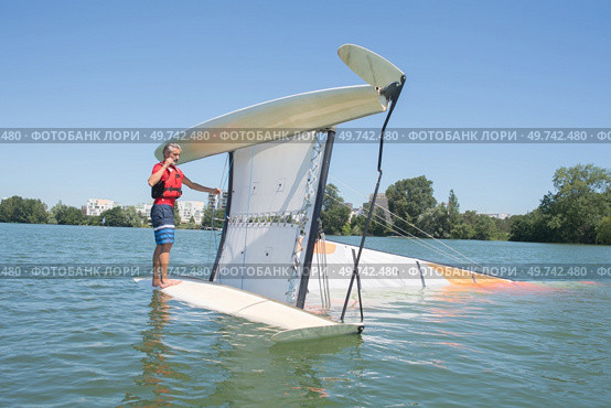 salior trying to right his catamaran after capsize. Стоковое фото, агентство Ingram Publishing / Фотобанк Лори