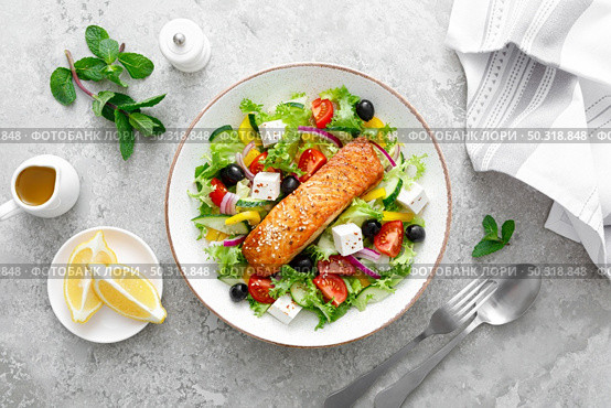 Salmon fish salad. Fresh vegetable greek salad with tomato, pepper, lettuce, olives, cucumbers, feta cheese and grilled salmon fish fillet in bowl, healthy food, omega 3, keto diet, mediterranean cusine, top view. Стоковое фото, агентство Ingram Publishing / Фотобанк Лори