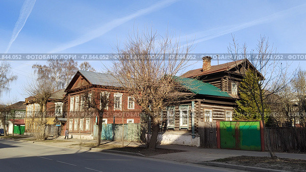 Самобытные деревянные дома в русском городе.  Улица с традиционной архитектурой. Двухэтажные дома и дома с мезонином из бревен и бруса с резным декором на окнах. Россия, Кострома, 17 апреля 2025. Wooden houses in Russian city.  Street with traditional architecture. Two-storey houses and house with mezzanine made of logs and timber with carved decorations on windows. Kostroma, Russia, 4.17.2025. Редакционное фото, фотограф Ирина / Фотобанк Лори